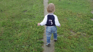 蹒跚学步的小男孩走在草地上29秒视频