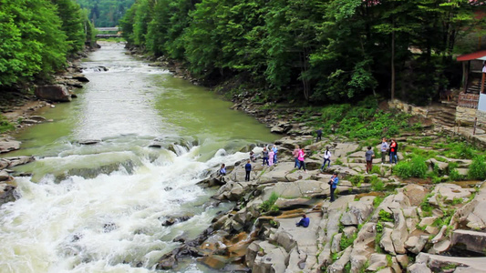 游客在乌克兰喀尔巴阡山亚雷姆奇瀑布附近的山脉视频