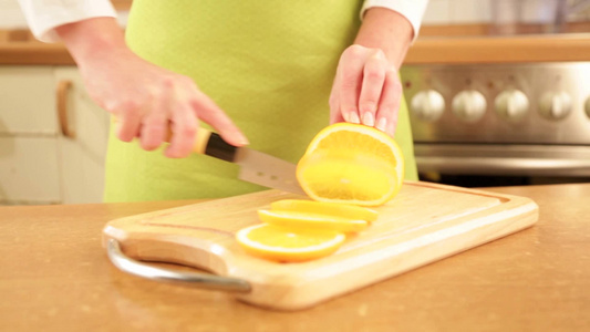 厨房切橙子的女人手部特写镜头视频