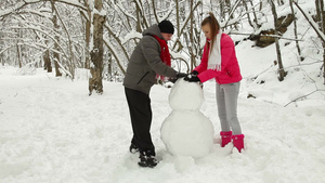 下雪的森林里夫妇堆雪人20秒视频