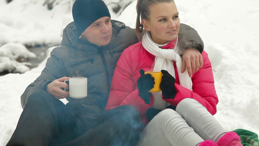 年轻夫妇在雪林的篝火旁享受假日的幸福视频