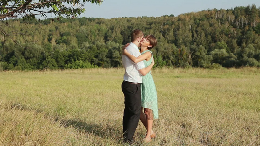 年轻夫妇在草地上拥抱[绿茵茵]视频