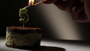 点燃提拉米苏蛋糕里的5岁生日蜡烛29秒视频