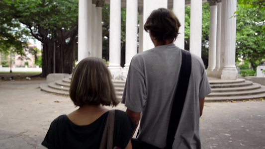 男孩和女孩在城市公园散步牵着手看纪念碑视频