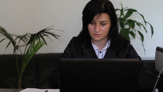 年轻的女人在办公室里使用电脑视频
