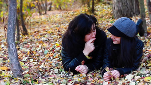 母亲带着孩子躺在城市公园的树叶上29秒视频
