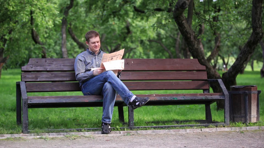 男子在长凳上看报纸视频