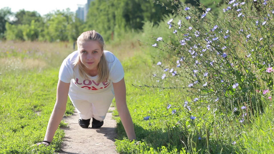 年轻的女人在公园锻炼做俯卧撑[二十多岁]视频