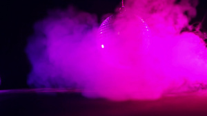 圆形镜面银色迪斯科球在黑暗中反射紫色的光气氛中充满烟雾7秒视频
