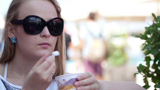 女子戴太阳镜在街头咖啡馆吃冰淇淋视频