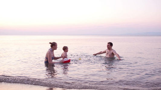 一家三口在日落的海边游泳嬉戏视频