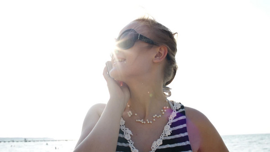 微笑的年轻女人戴着太阳镜打电话[二十多岁]视频