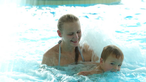 年轻女子和小男孩在游泳池玩耍10秒视频