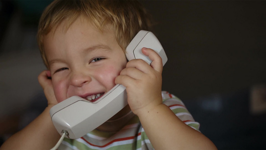 一个兴奋的小男孩在电话上交谈特写视频