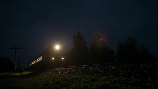 夜晚一列明亮的火车快速穿过农村地区的视频