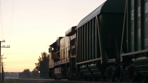 货运火车在日落时在乡下慢慢地靠近又渐渐远去的景色29秒视频