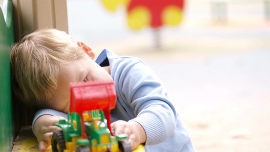 小男孩在户外玩玩具车[电动玩具]视频