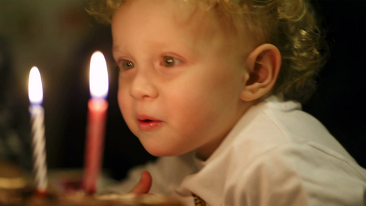 小男孩在生日蛋糕上吹灭两支蜡烛视频