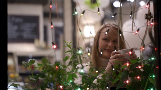女人在咖啡馆喝茶看圣诞灯视频