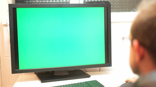 商务人士坐在办公室里对着绿色屏幕的电脑[家庭用户]视频