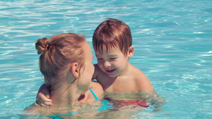 年轻女子和小男孩在游泳池中游泳13秒视频