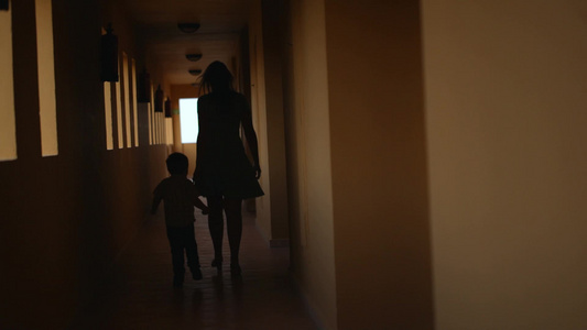 母亲带着她的儿子沿着酒店走廊行走视频