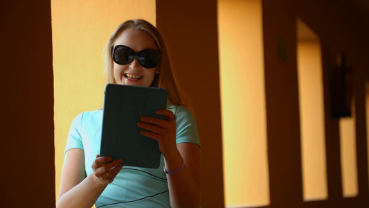 戴着太阳镜的年轻女子使用平板电脑进行视频聊天视频
