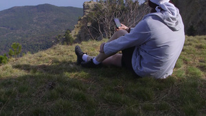 徒步旅行者坐在山顶听音乐12秒视频