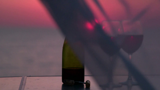 美丽的日落的海边餐桌上放着两杯红酒视频