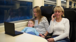 火车上的女子陪小男孩在电脑上看电影老人打电话18秒视频