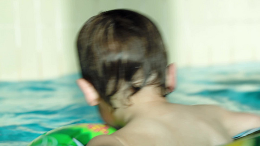 橡胶圈在游泳池里游泳的小男孩视频