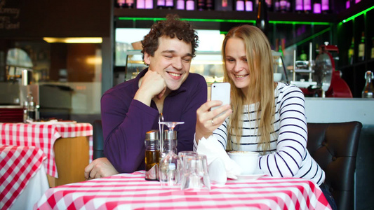 快乐的年轻人在咖啡馆使用智能手机进行视频聊天[永远快乐]视频