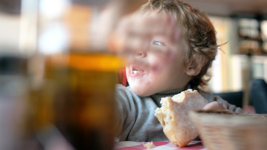 一个可爱的小男孩吃面包特写镜头视频
