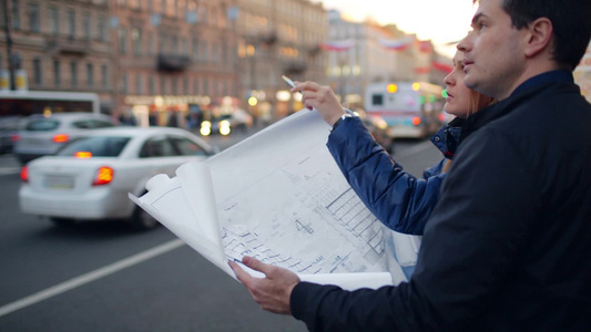 年轻的建筑师站在城市街道上讨论建筑规划视频