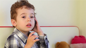 小男孩在家用智能手机说话25秒视频