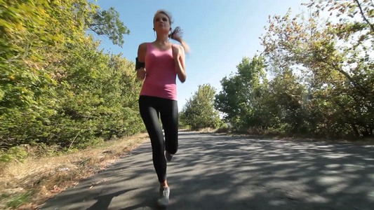 年轻的女人在乡村道路上健身慢跑锻炼[二十多岁]视频