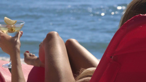 带着鸡尾酒杯的年轻女人在温暖的海滩上度假10秒视频