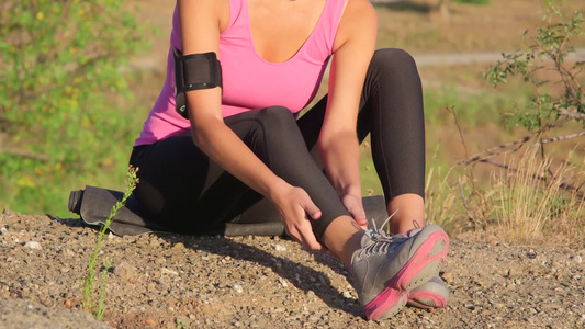 年轻妇女在户外锻炼时按摩腿部肌肉[二十多岁]视频