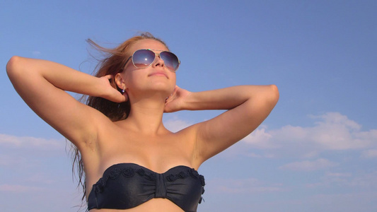 女孩在海滩上晒日光浴视频