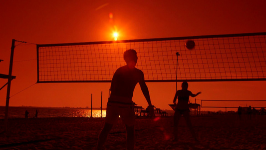 日落时玩沙滩排球的人视频