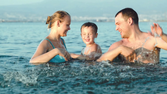 年轻夫妇和小男孩在海里玩水[男孩儿]视频