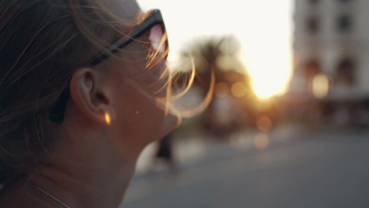 年轻的女人戴着太阳镜微笑着看向远方[二十多岁]视频
