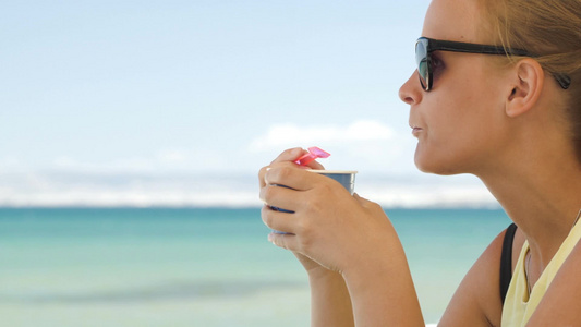 年轻的女人在海滩上吃冰淇淋视频