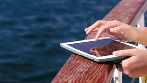 海上旅行女人把平板电脑放在船栏杆上在不停地输入文字信息19秒视频