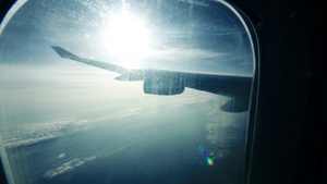 从照明器观看飞机机翼下有太阳耀斑和云层17秒视频