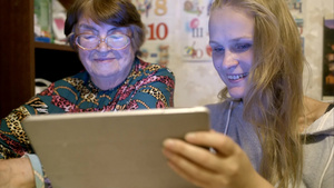 祖母和孙女用平板电脑查看照片微笑着交谈23秒视频