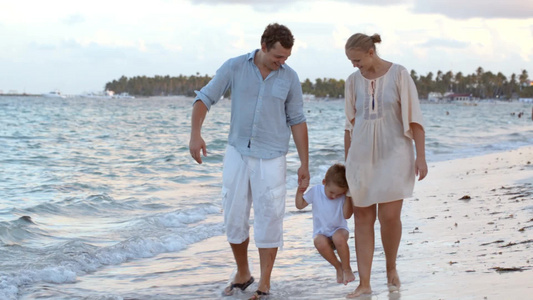 幸福的家庭沿着热带的海岸散步视频