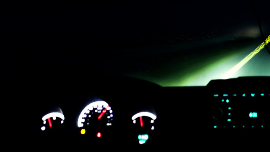 晚上开车从里面看有发光的仪表板和道路灯视频
