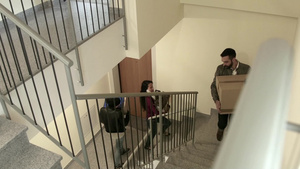 三个年轻人搬着纸箱走在楼梯上26秒视频
