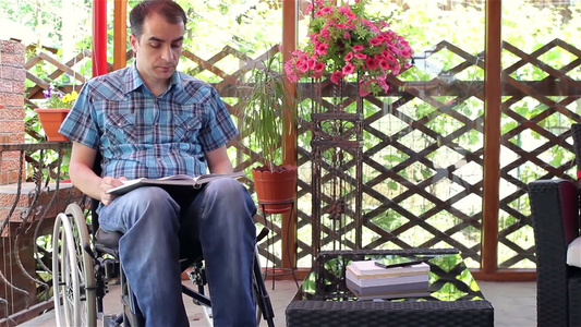 坐轮椅的年轻人在户外看书[看看书]视频